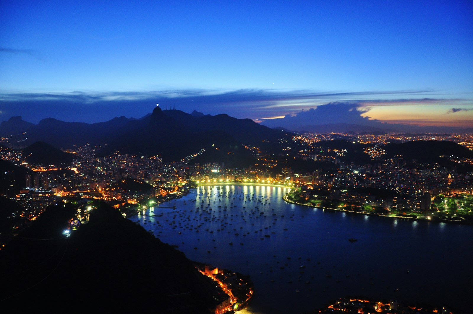 Rio de Janeiro at blue hour, seen from above, with the city lights coming on around the lagoon